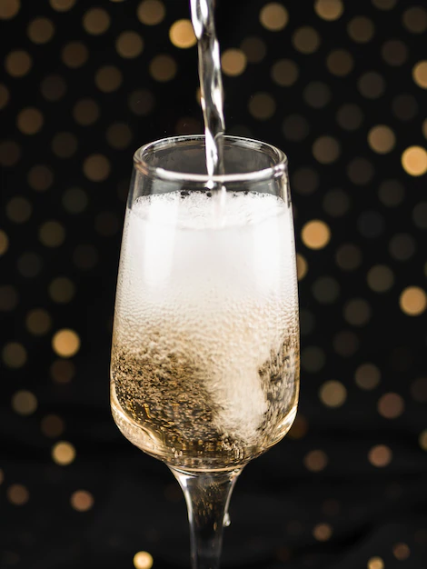 champagner-der-in-glas-mit-schaum-giesst.webp